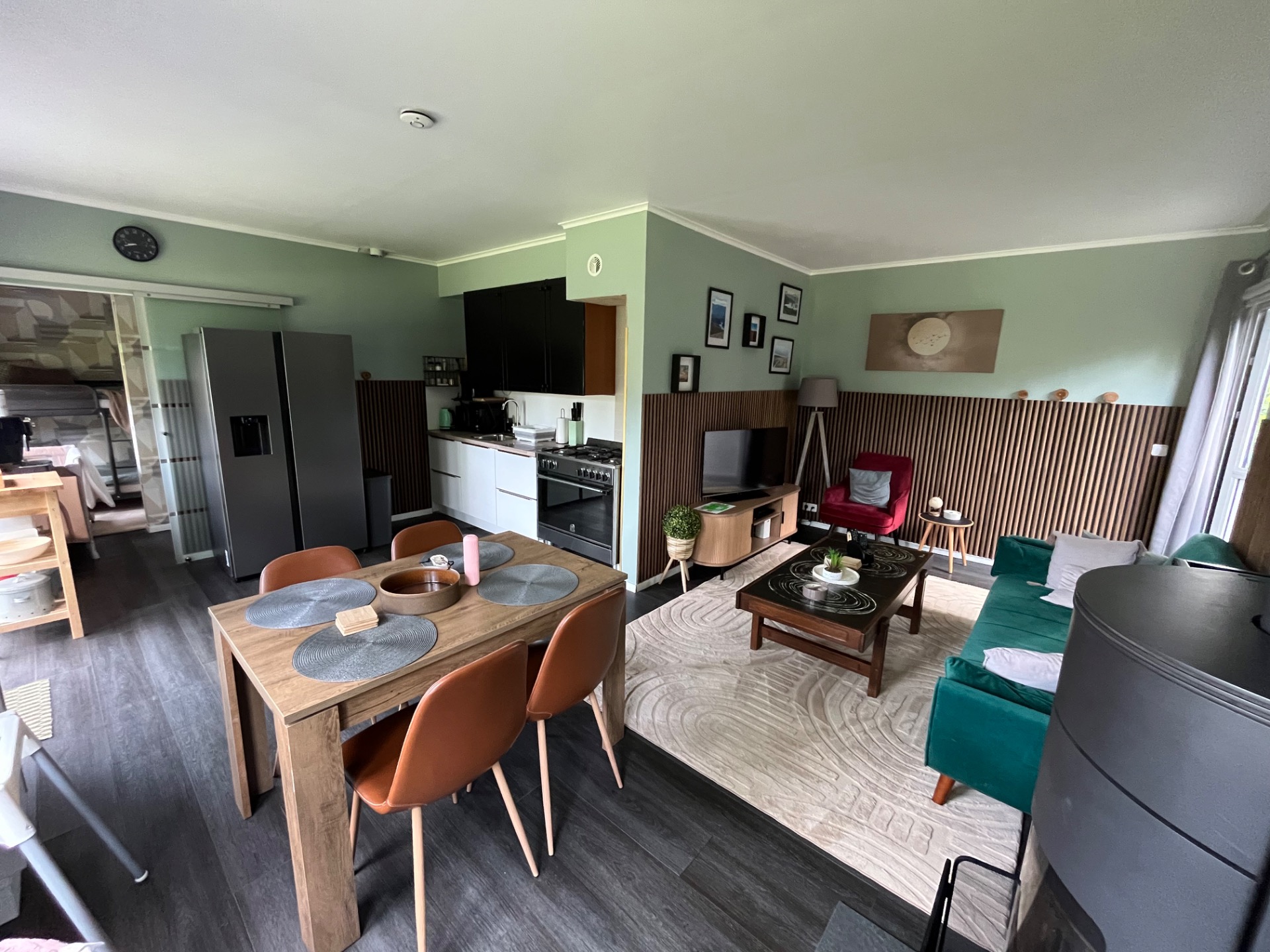Lichte woonkamer met eettafel, keukenhoek en TV hoek